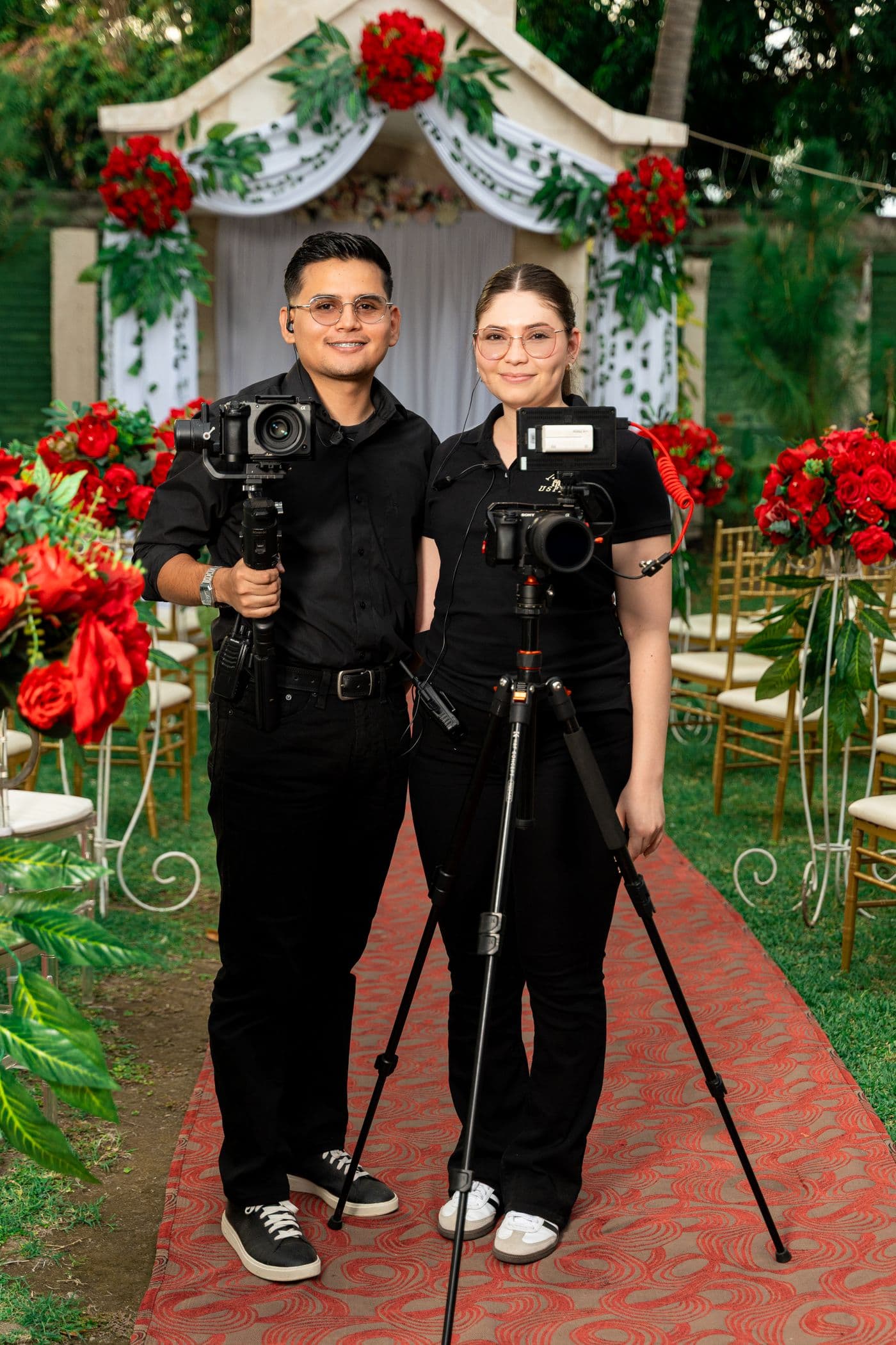 Un cameraman și o fotografă cu echipament, la o nuntă