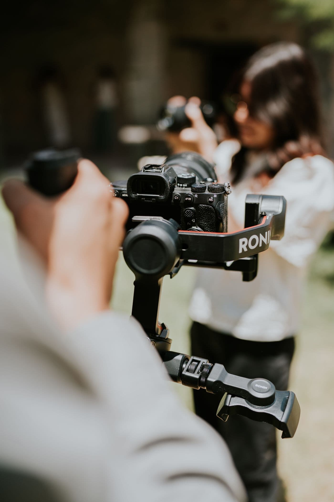 Doi operatori filmând, unul cu camera pe stabilizator